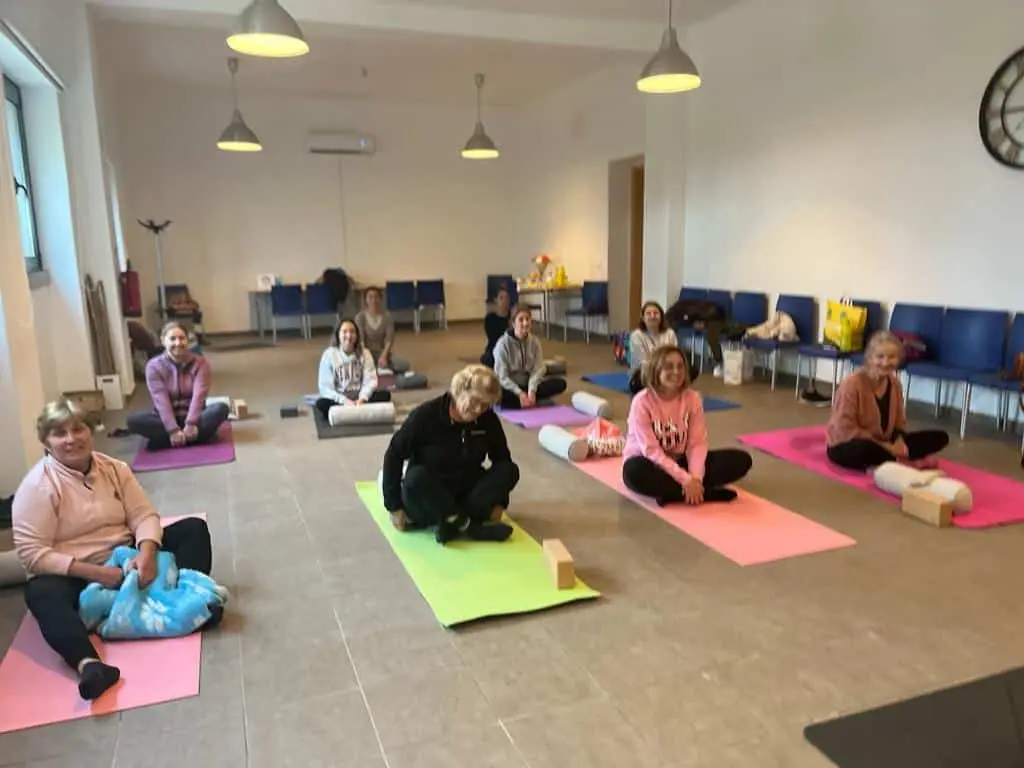Group yoga class in spacious indoor setting.