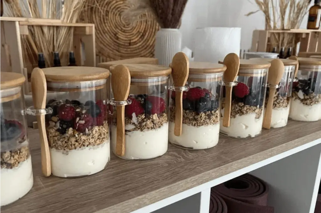 Jars of yogurt parfaits with granola and berries.