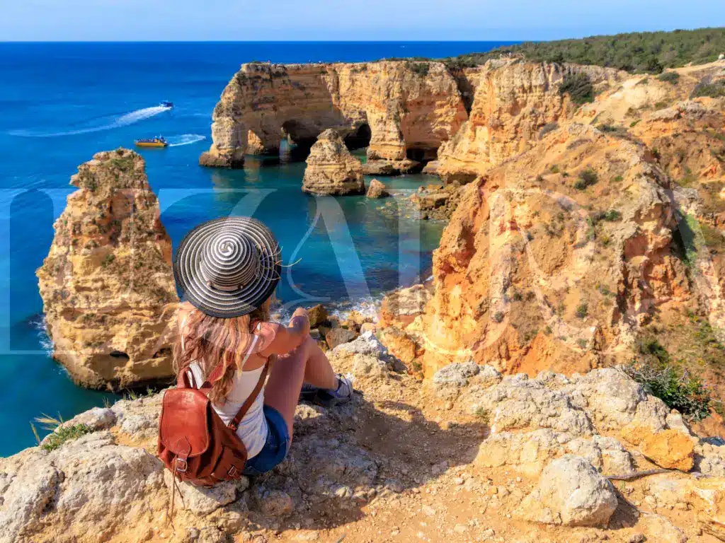 Woman overlooking the Algarve cliffs on a community hike.